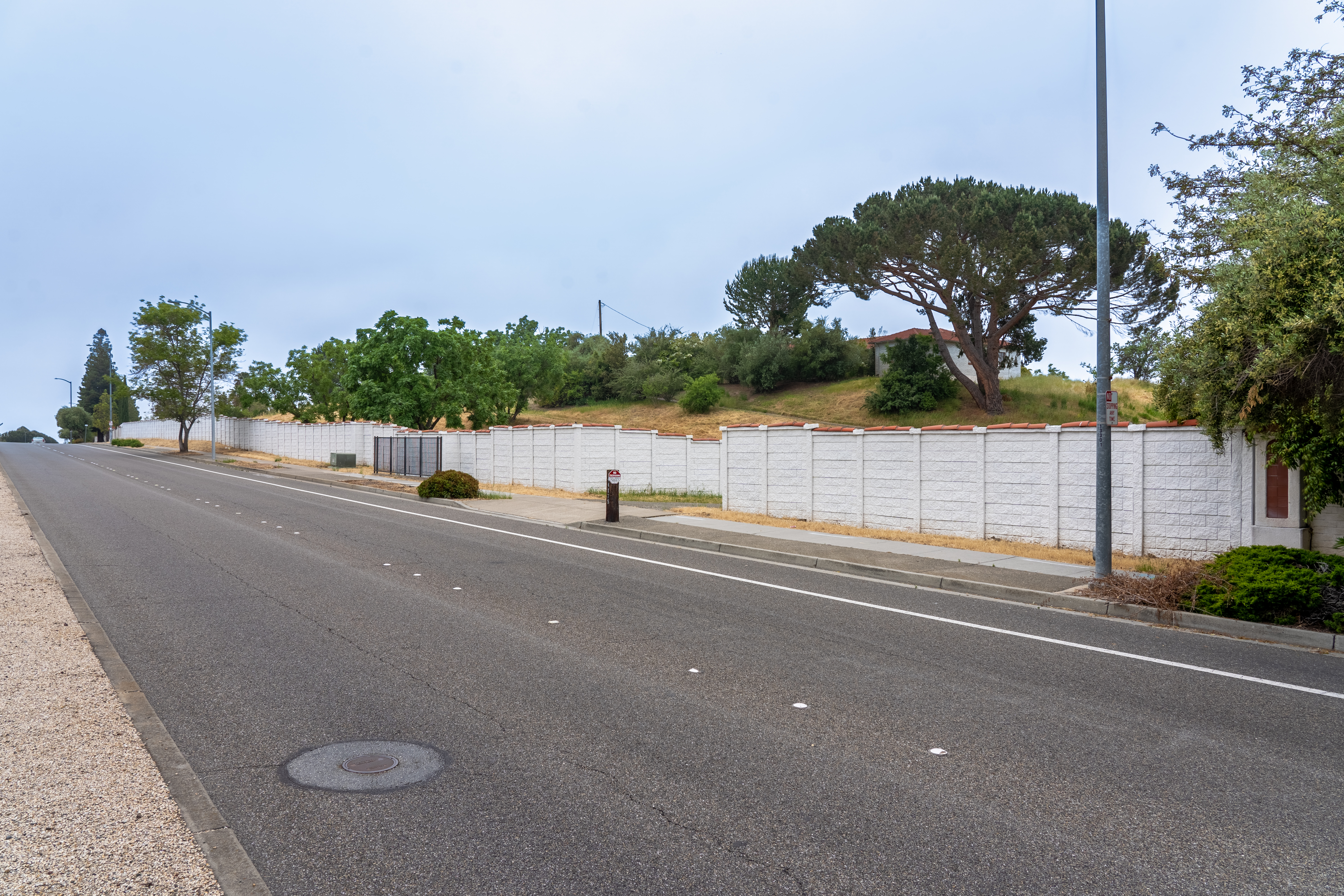 Precast concrete sound barrier wall along a California freeway at sunset, protecting residential neighborhood from highway noise