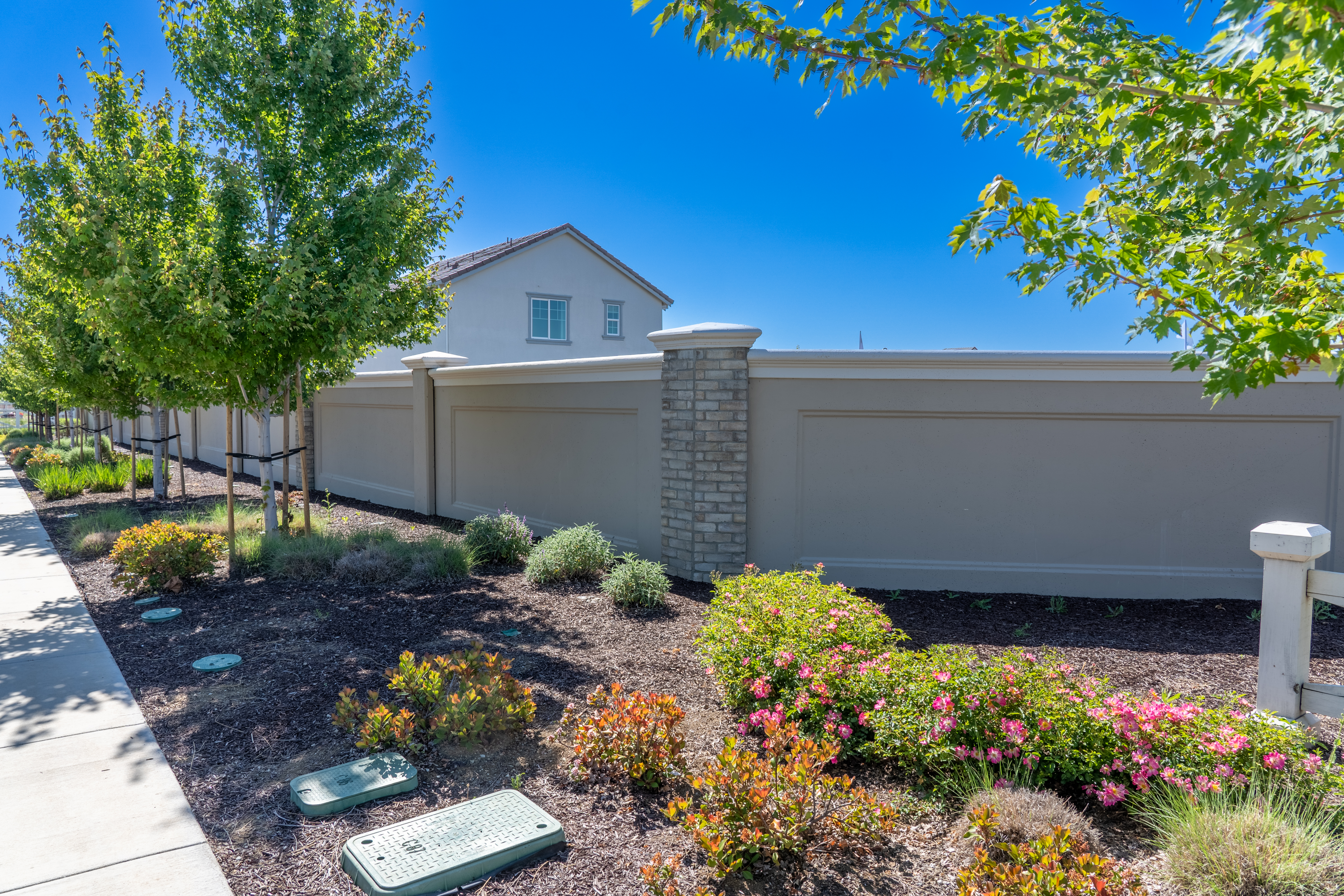 Elegant precast concrete perimeter fence surrounding a luxury California residential community with palm trees